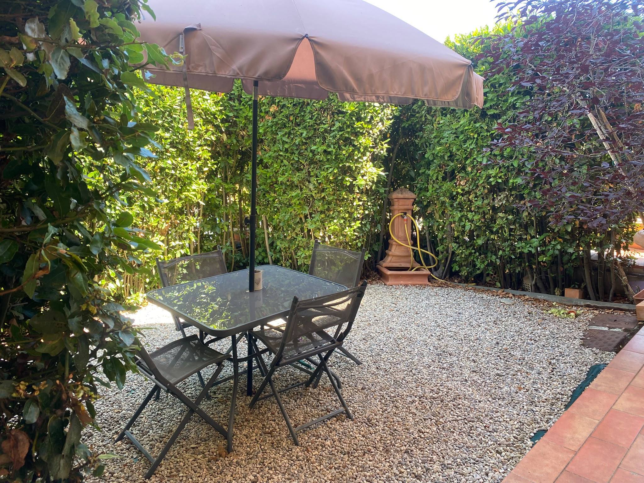 Giardino privato con tavolo e ombrellone — B&B Lulù, Impruneta (Firenze)